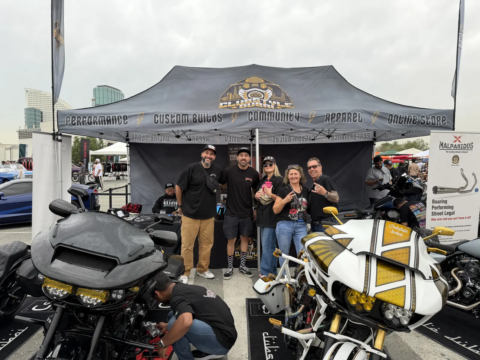 Clubstyle Dubai crew at their event booth between two custom Harley baggers