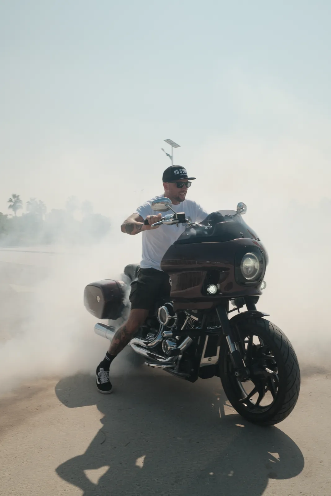 Rider holding a burnout on a custom bagger in a cloud of tyre smoke