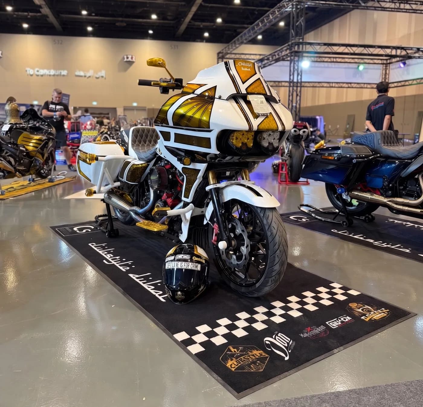 White-and-gold custom clubstyle Road Glide on a Clubstyle Dubai mat at a Dubai bike show