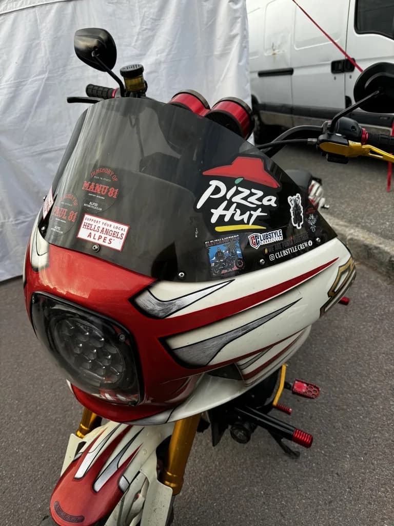 Sticker-covered clubstyle windscreen at a French bike show — Pizza Hut, Hells Angels Alpes, Clubstyle Crew
